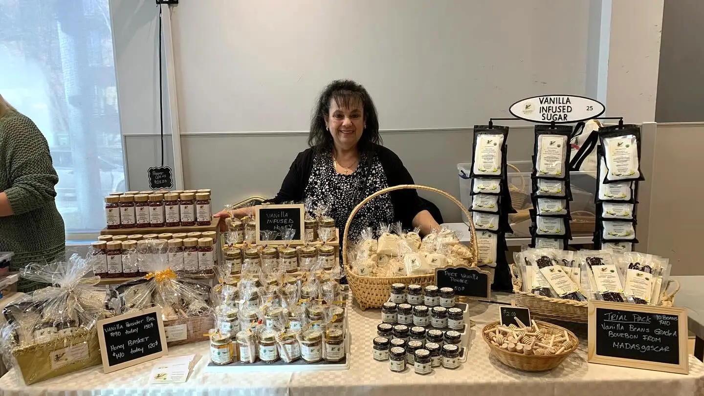 Josie at her market table with jars of vanilla and spices